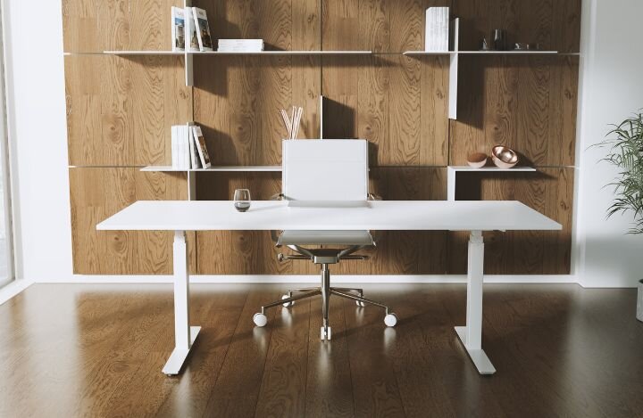 Ein Schreibtisch vor einer Holzwand und mit weißem Stuhl.